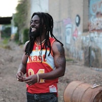 a man with dreadlocks and a basketball jersey